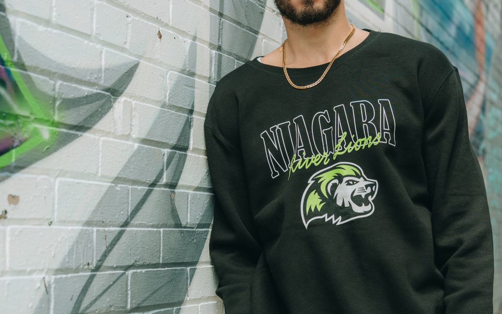 A man wears a Niagara River Lions sweatshirt.
